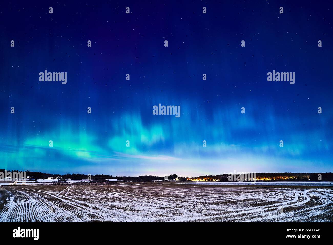 Una splendida esposizione dell'aurora boreale che illumina il cielo e un campo pittoresco Foto Stock
