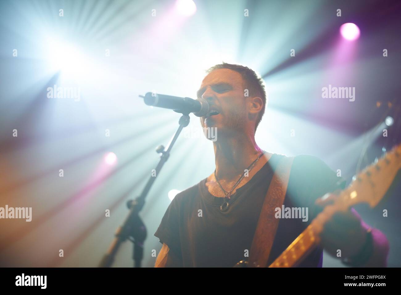 Canta, concerto e uomo con chitarra e microfono per canzoni e performance disco. Spettacolo dal vivo, persona maschile e club musicale artistico per la vigilia di Capodanno Foto Stock