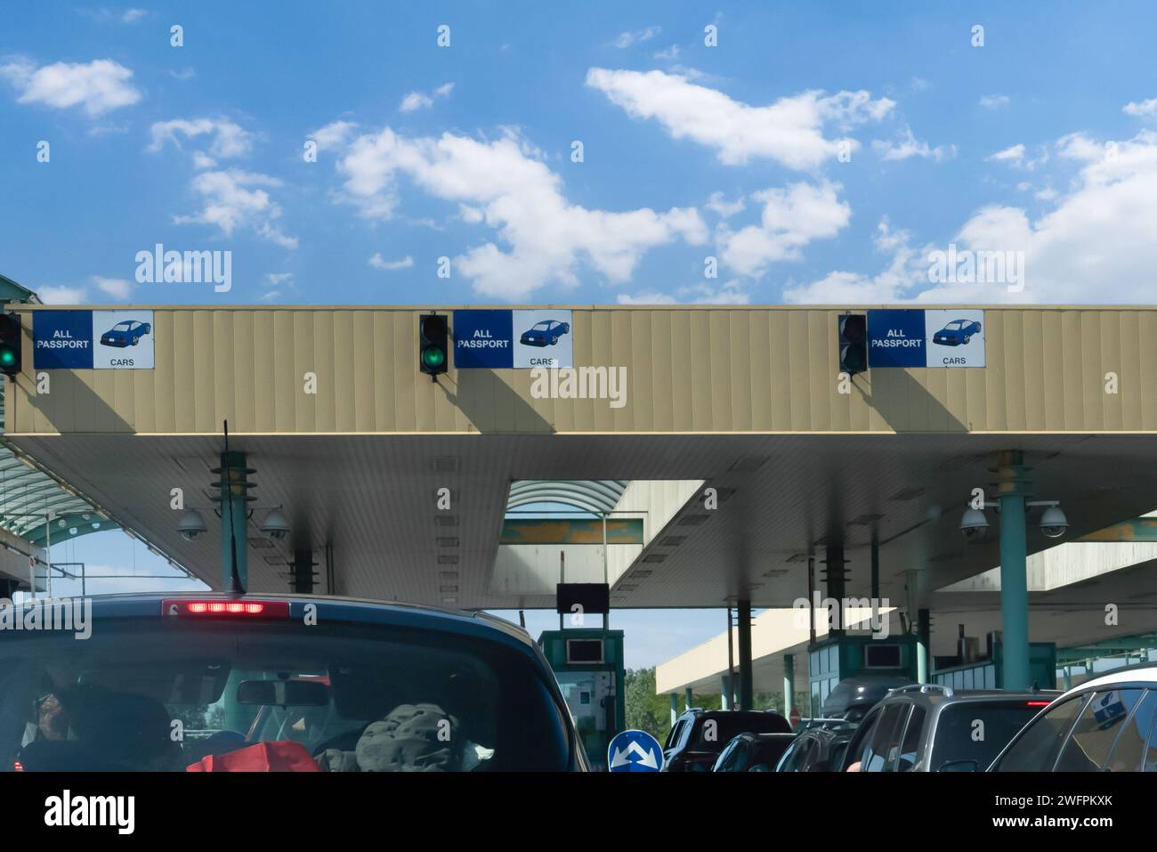 Checkpoint doganale per le auto. Verifica del passaporto e ispezione dei documenti al valico di frontiera. Segnale di attraversamento del confine europeo con semaforo verde. Foto Stock