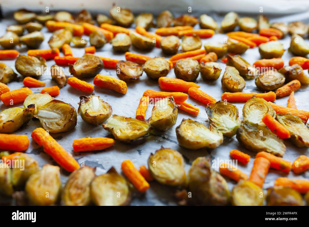 Carote arrostite e cavoletti di bruxelles a fette su una teglia da forno Foto Stock