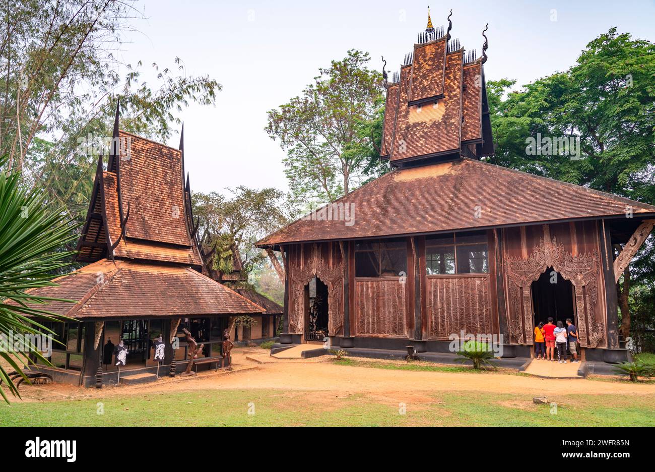 Chiang Rai, Thailandia - marzo 31 2023: All'interno di un vasto e squisito terreno, una collezione di strutture in legno scuro e nero e manufatti, con opere di T. Foto Stock