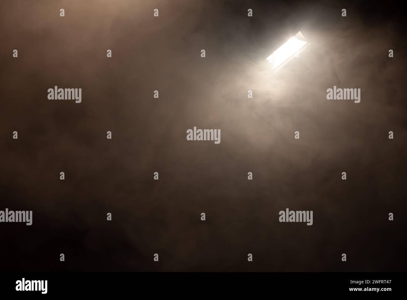 grande spot luminoso in camera piena di fumo Foto Stock