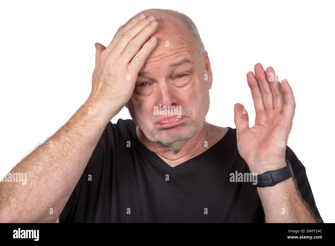 Uomo di mezza età che esprime dolore e stress, Ritratto in T-shirt nera, affrontare il disagio emotivo su sfondo bianco - concetto di salute mentale Foto Stock