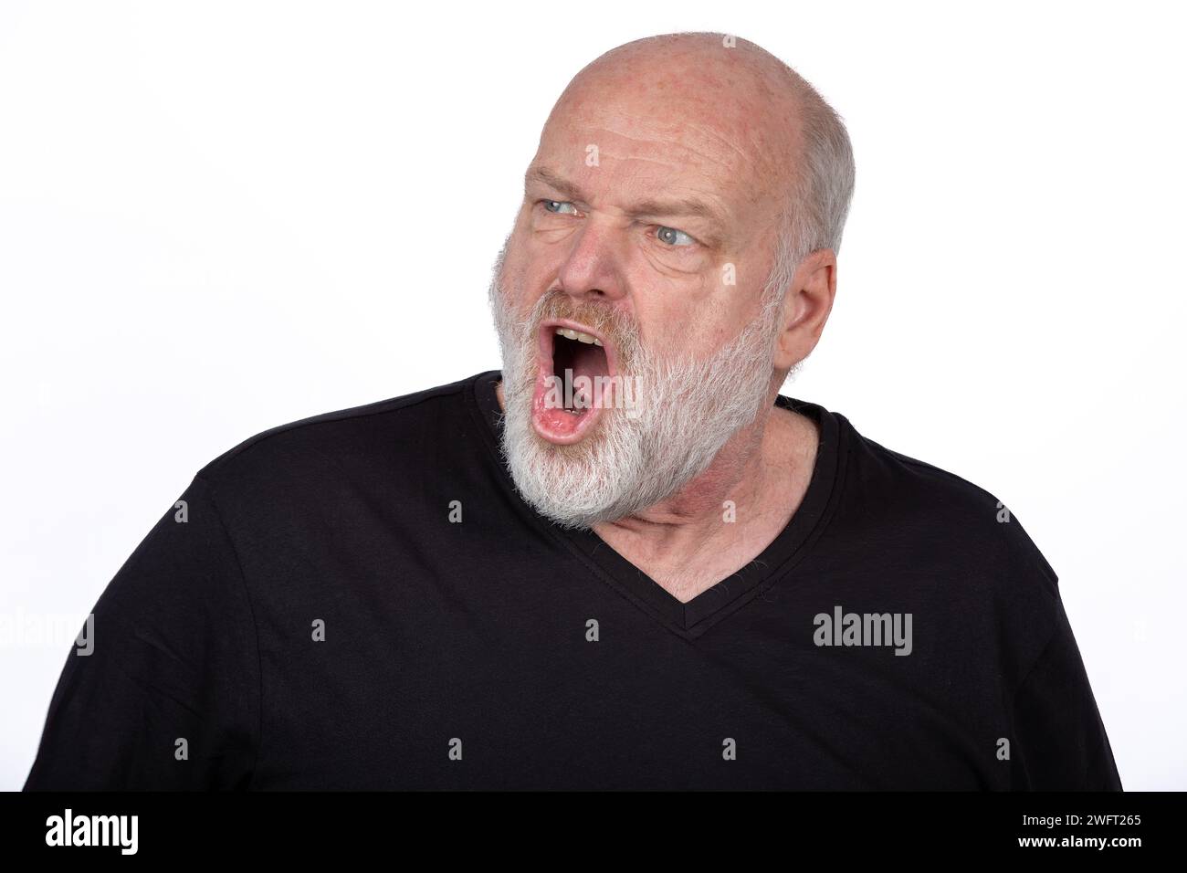 Intenso uomo barbuto medioevale che grida di rabbia con T-shirt nera, emozione espressiva del viso su sfondo bianco - Ritratto emotivo potente Foto Stock