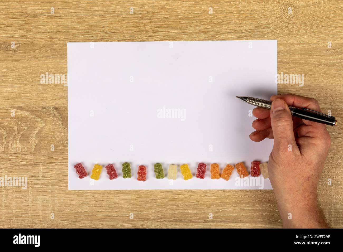 Insegnamento con mano destra: Scrittura creativa con dolci dolcetti per bambini su White paper con spazio copia Foto Stock