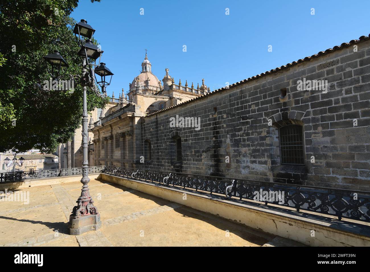 Vista laterale dell'antica cattedrale di Jerez de la Frontera, splendidamente dettagliata, sotto un cielo azzurro. Foto Stock