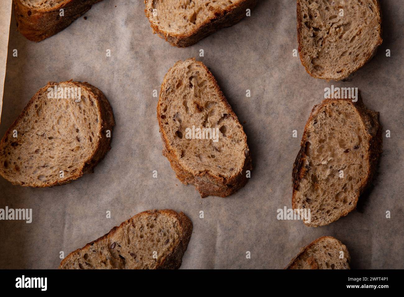 Fette di pane multigranato artigianali su carta da forno. Foto Stock
