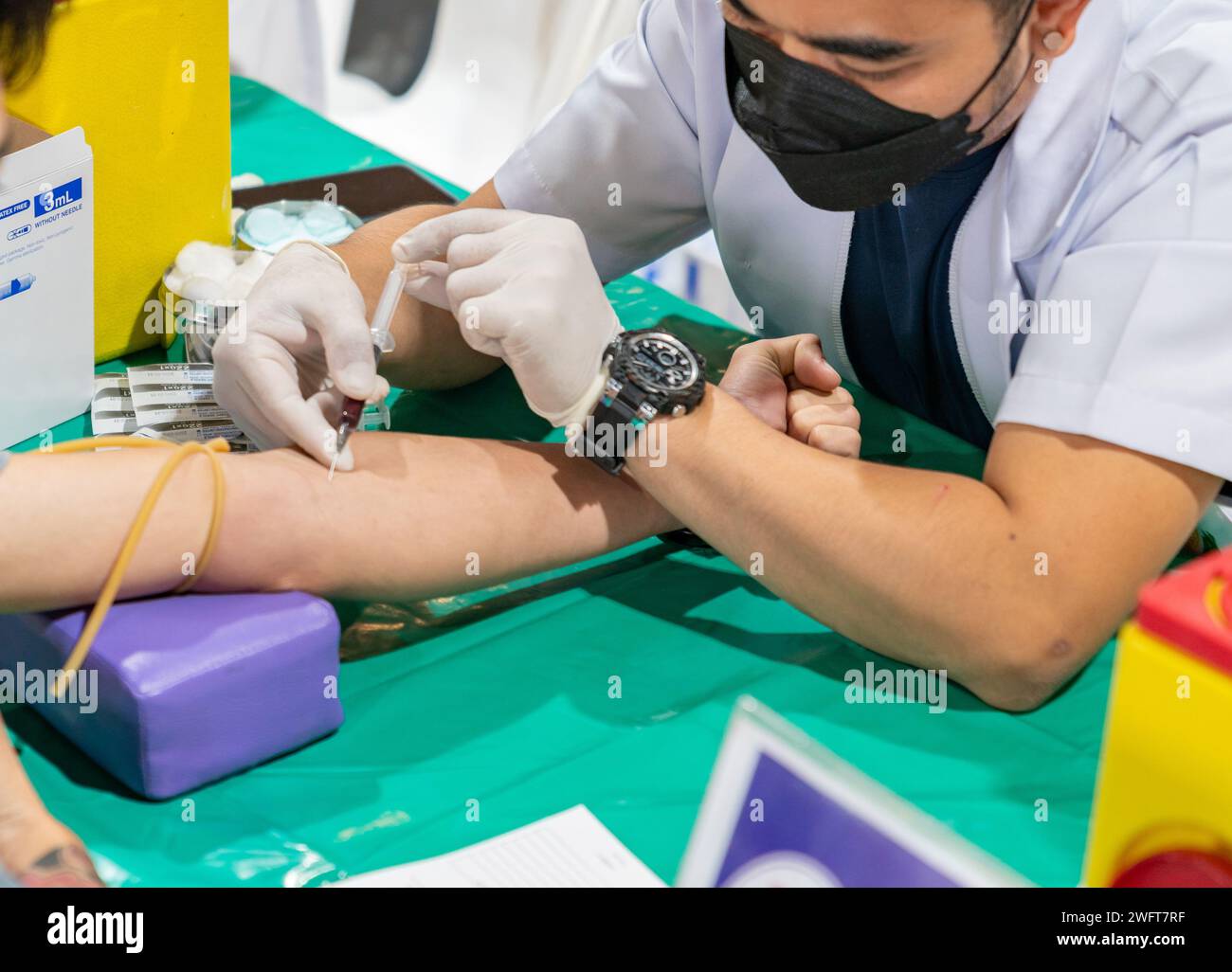 Flebotomista che raccoglie il campione di sangue dal paziente in ospedale. Foto Stock