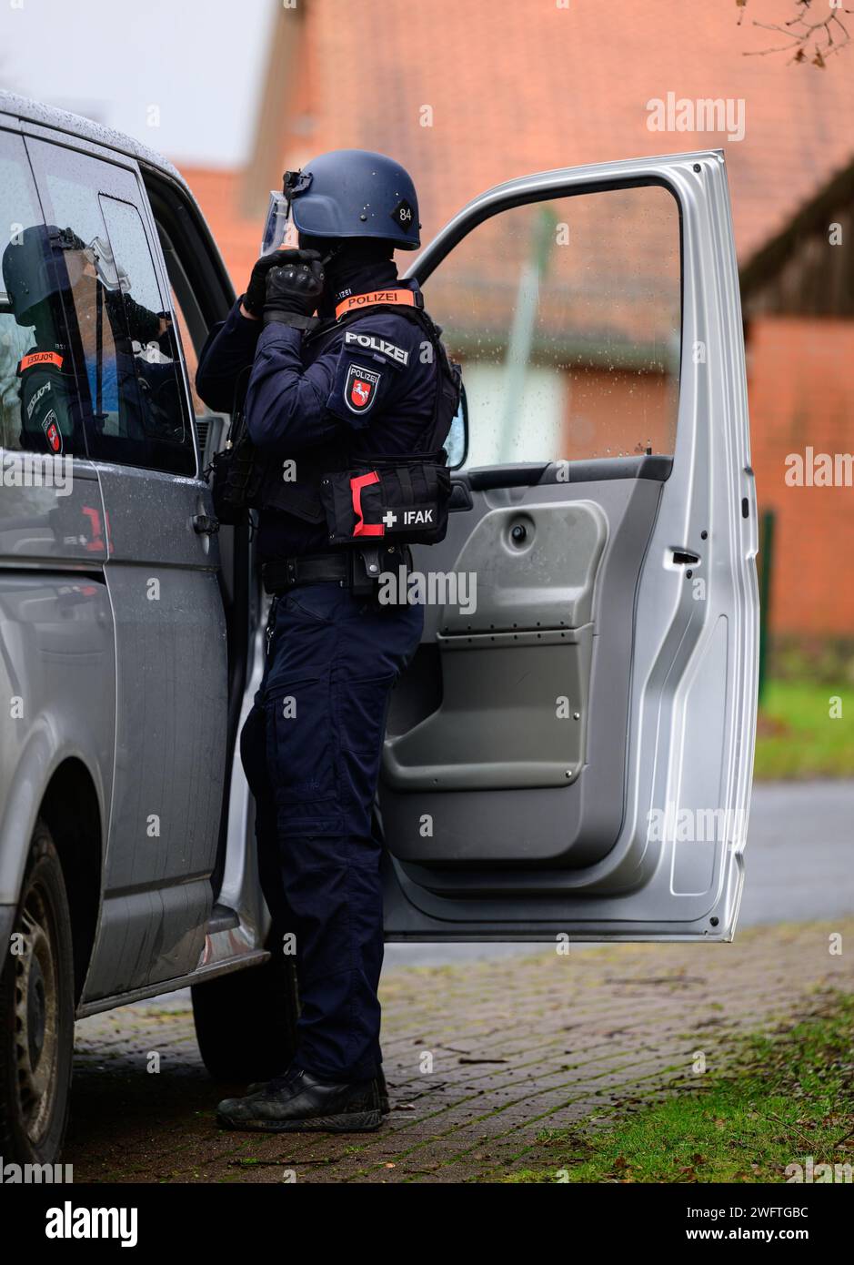 PRODUZIONE - 03 gennaio 2024, bassa Sassonia, Hohenbostel: Un agente di polizia dell'unità di smaltimento di Lüneburg si equipaggia durante un esercizio. Foto: Philipp Schulze/dpa Foto Stock