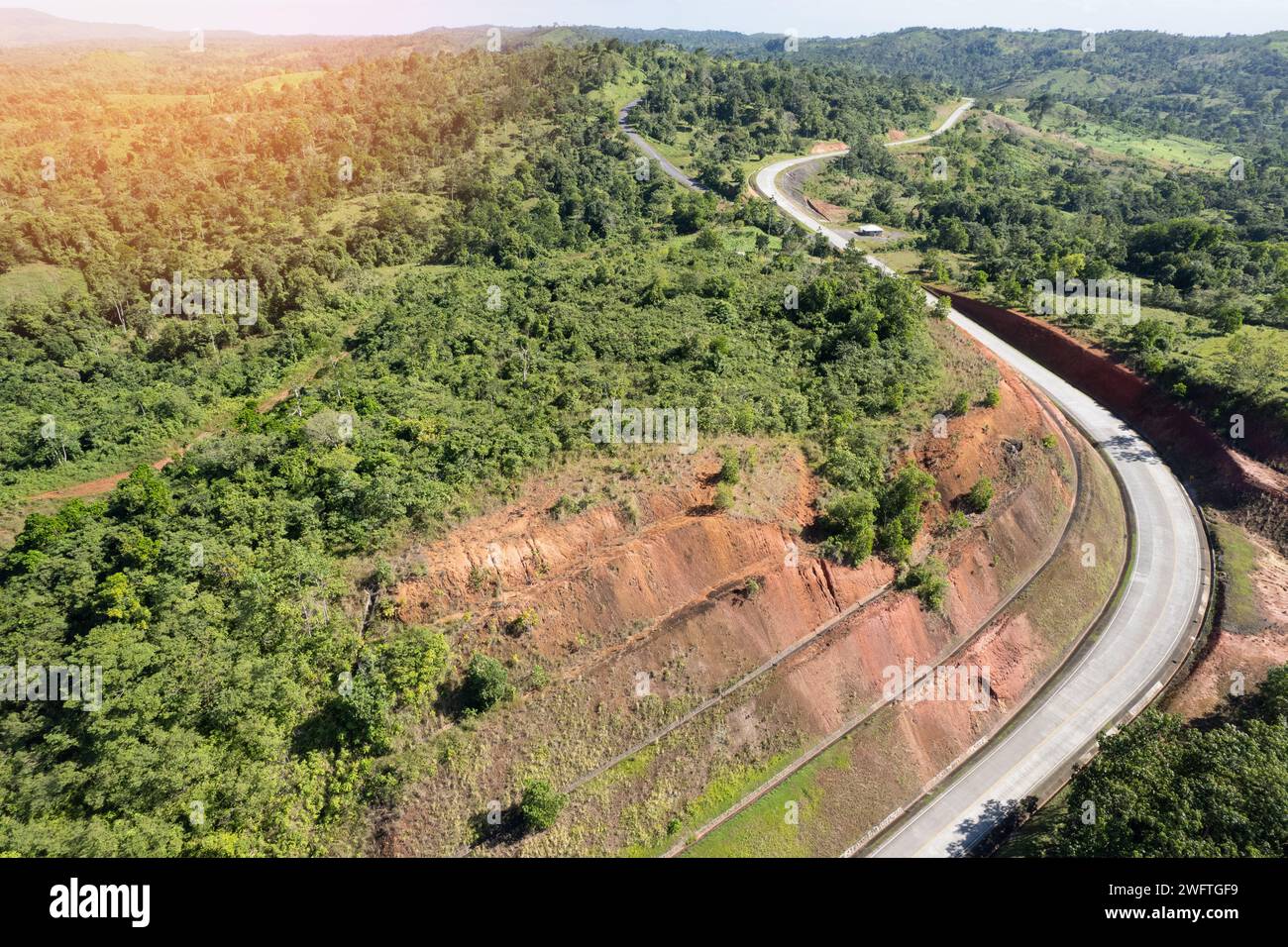 Strada sinuosa e vuota in verdi colline vista aerea con droni Foto Stock
