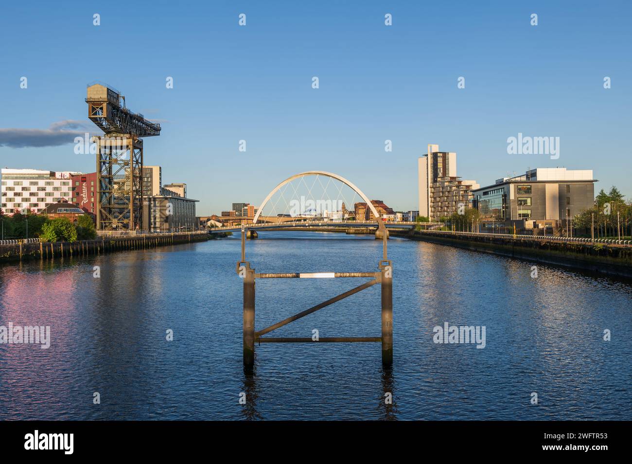 Skyline con Finnieston Crane e il ponte Clyde Arc sul fiume Clyde al tramonto nella città di Glasgow in Scozia, Regno Unito. Foto Stock
