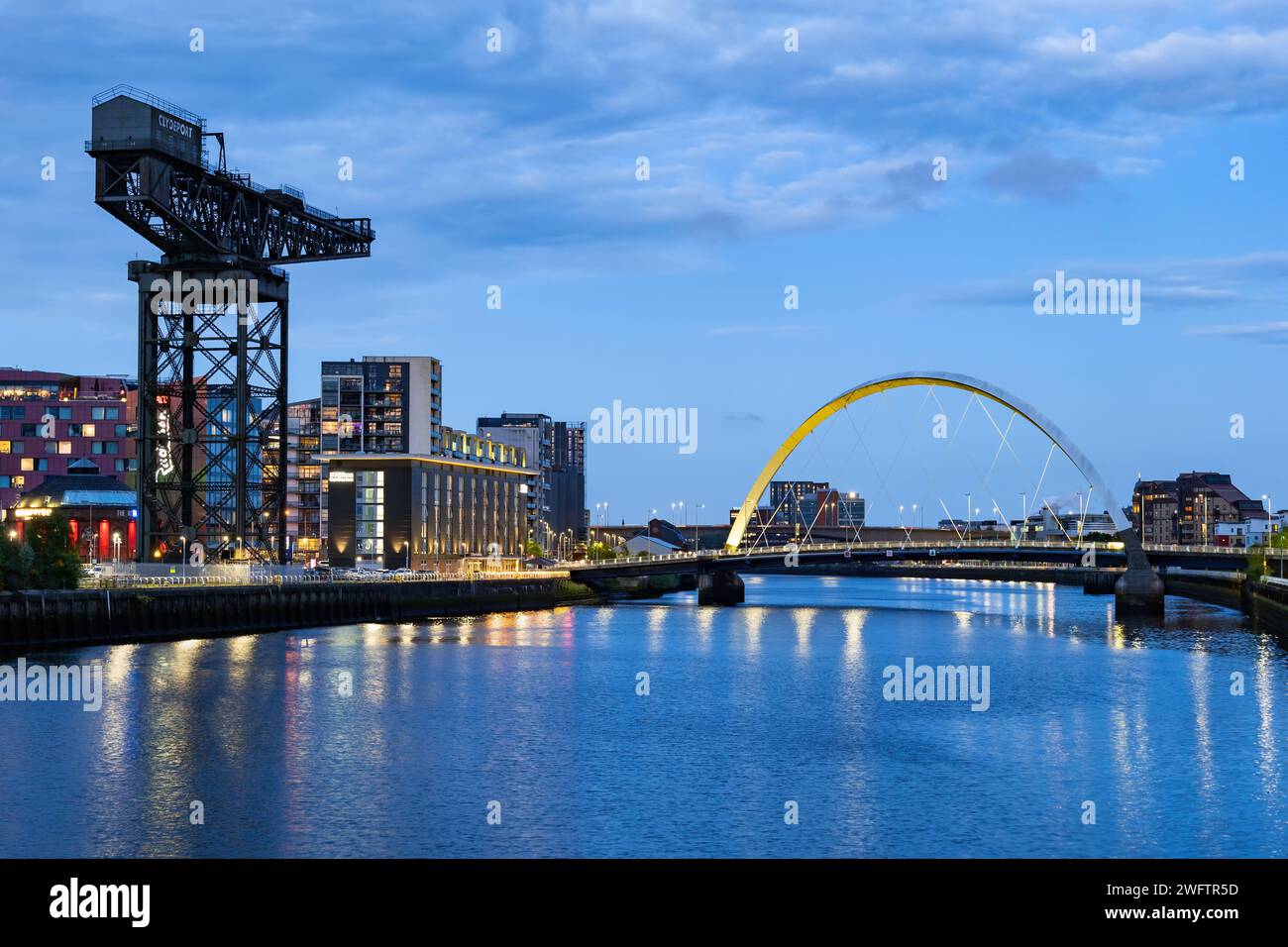 Finnieston Crane e Clyde Arc bridge sul fiume Clyde al crepuscolo nella città di Glasgow in Scozia, Regno Unito. Foto Stock