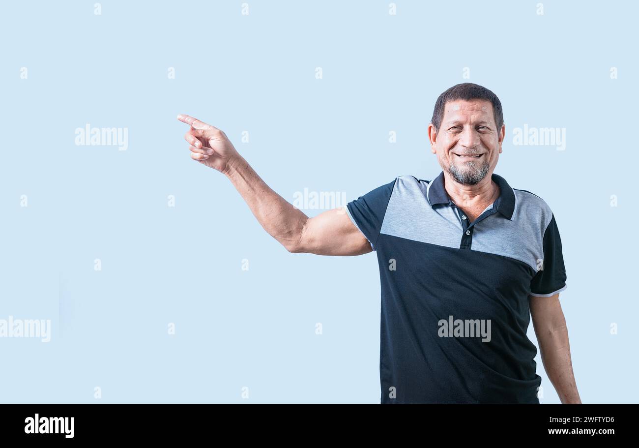 Un uomo anziano sorridente che indica il lato isolato. Uomo anziano felice che indica uno spazio pubblicitario isolato Foto Stock