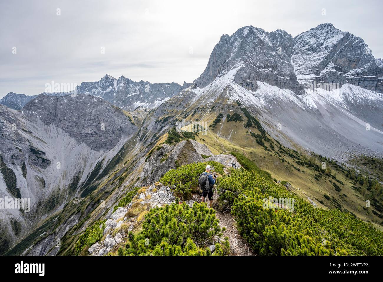 Alpinisti su un sentiero escursionistico sul crinale di Hahnkampl, panorama montano con ripide vette rocciose, vista sulla cima del Lamsenspitze, in autunno, Karwendel Foto Stock