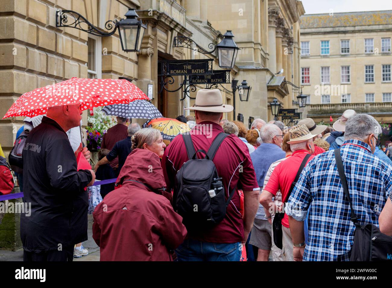 I turisti vengono fotografati in coda all'esterno delle famose sale pompe di Bath. Foto Stock