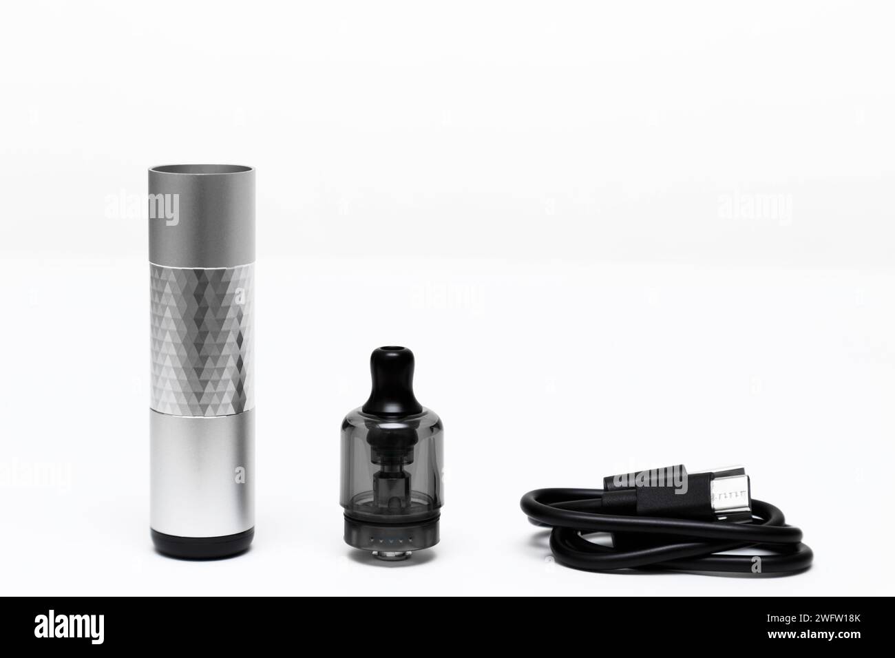 Dispositivo di vaporizzazione aperto, vape, pod, kit color argento con cavo di ricarica USB Type-C su sfondo bianco, vista laterale. Foto Stock