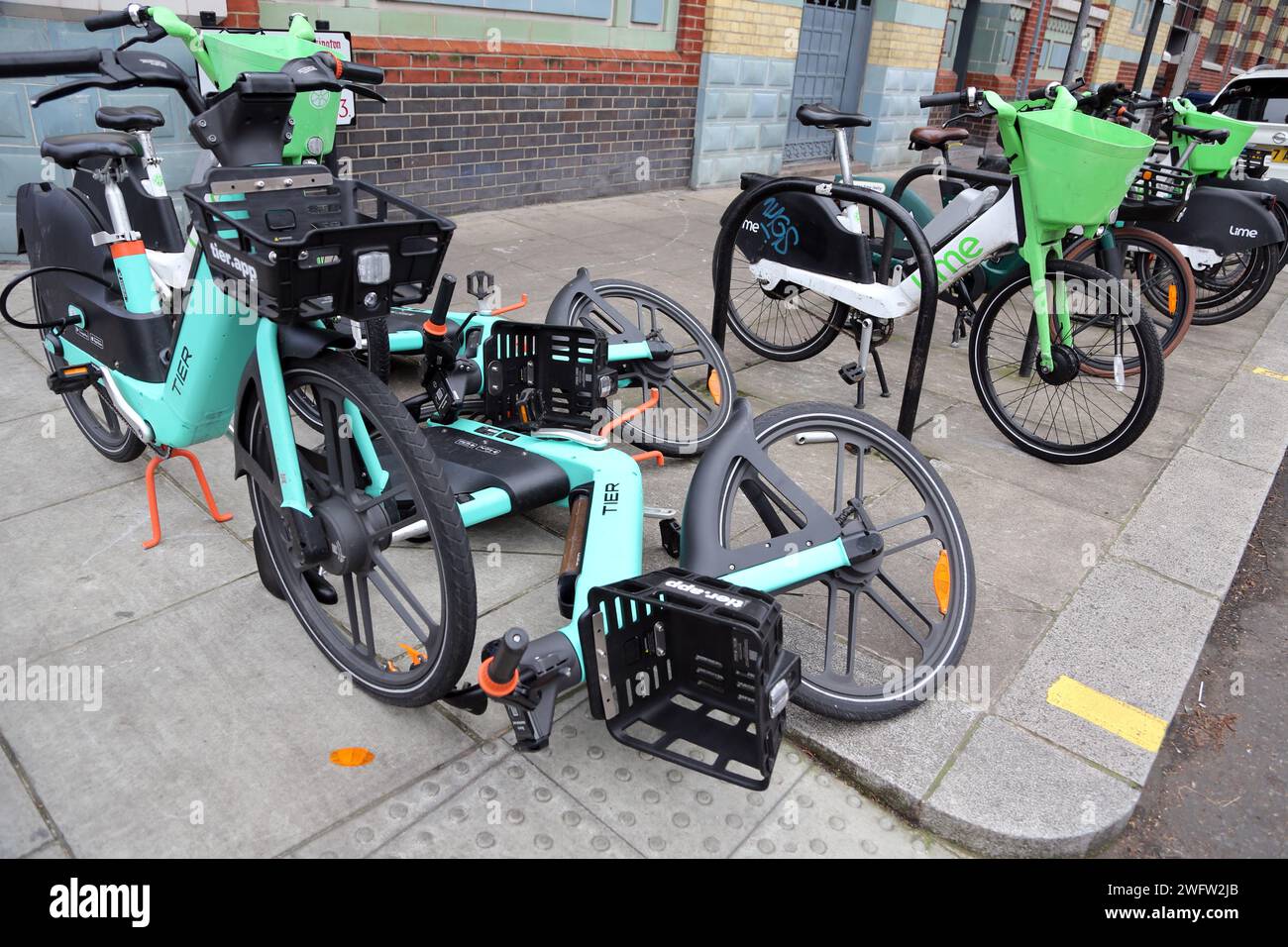 Sistema di noleggio biciclette senza porto Tier e Lime e-Bike su Pavement Chelsea Londra Inghilterra Foto Stock