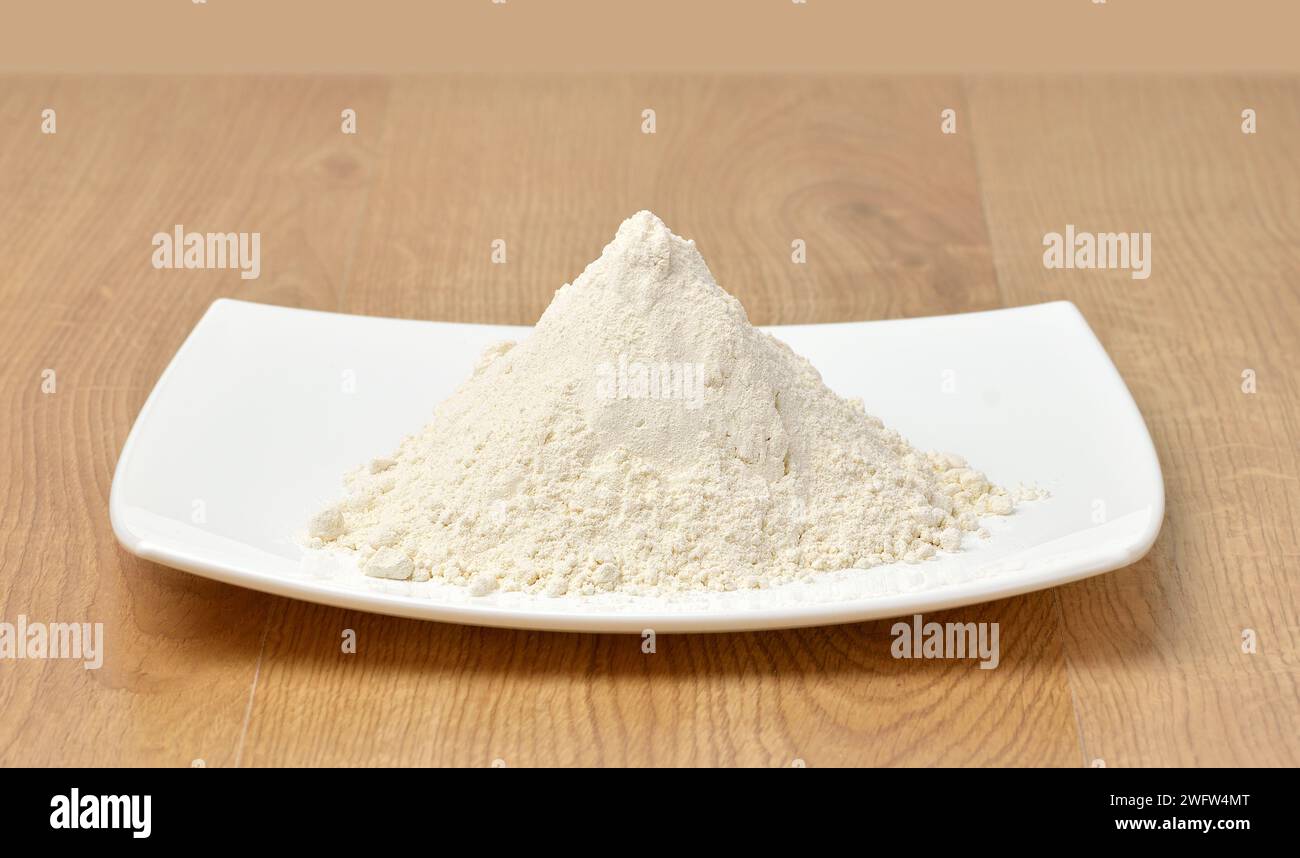 Mucchio di farina su fondo di legno Foto Stock
