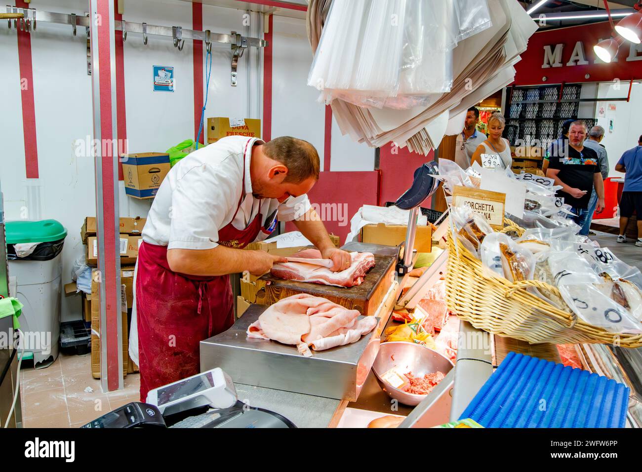 Un macellaio che prepara un taglio di carne al mercato centrale di Firenze, un mercato di prodotti freschi e di prodotti locali molto frequentato a Firenze, Italia Foto Stock