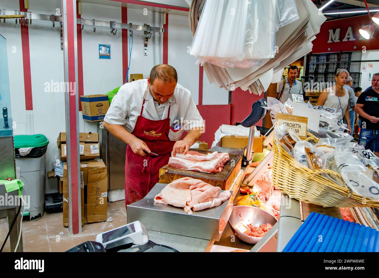 Un macellaio che prepara un taglio di carne al mercato centrale di Firenze, un mercato di prodotti freschi e di prodotti locali molto frequentato a Firenze, Italia Foto Stock