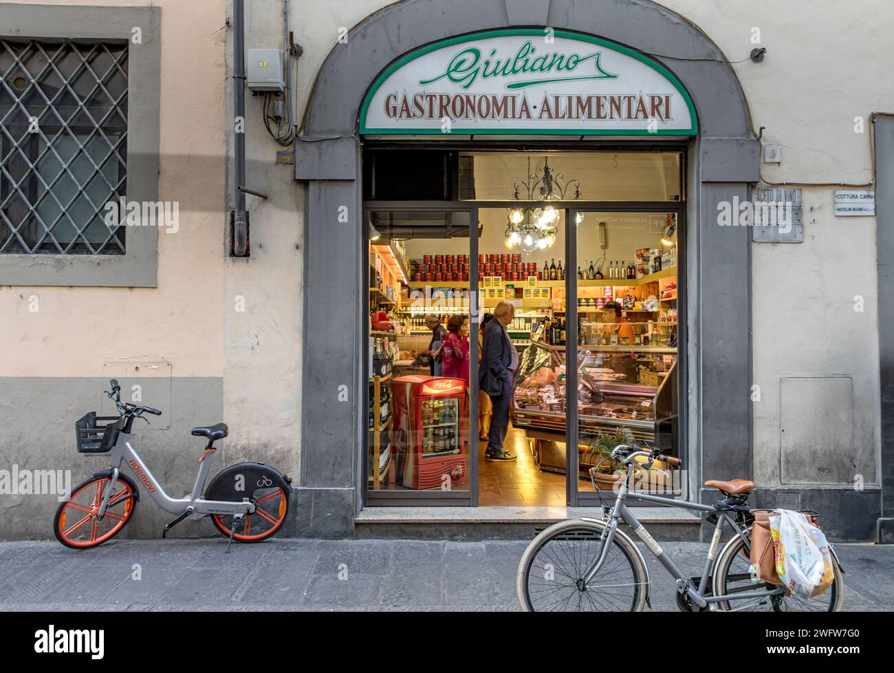 2 biciclette parcheggiate fuori dalla gastronomia Giulianoa , un negozio di alimentari gourmet a Firenze in via dei Neri, Firenze, Italia Foto Stock