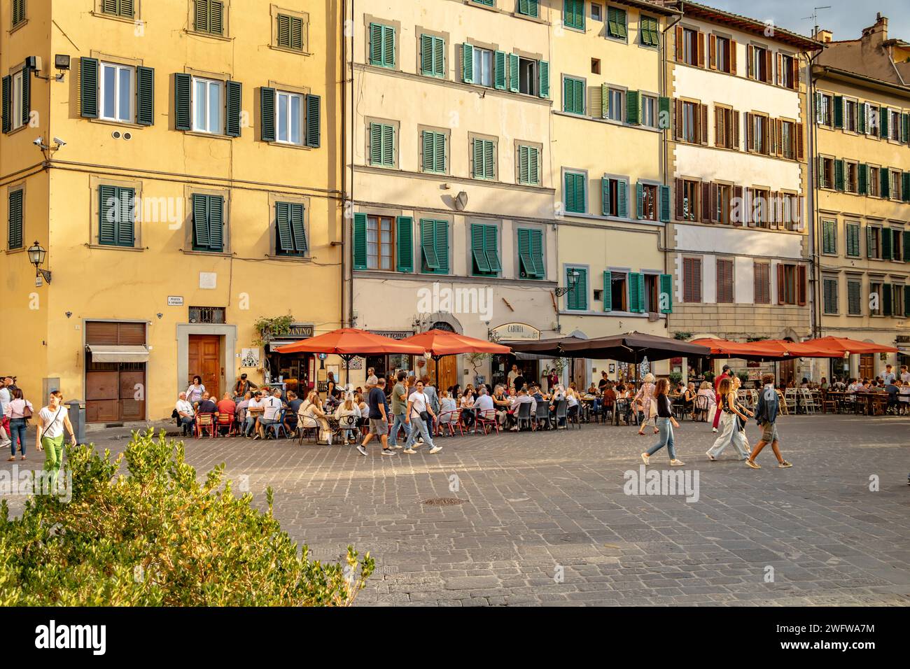 Le persone sedute all'esterno si godono cibo e bevande nei ristoranti e bar di Piazza Santo Spirito, nel quartiere Oltrano di Firenze, Italia Foto Stock