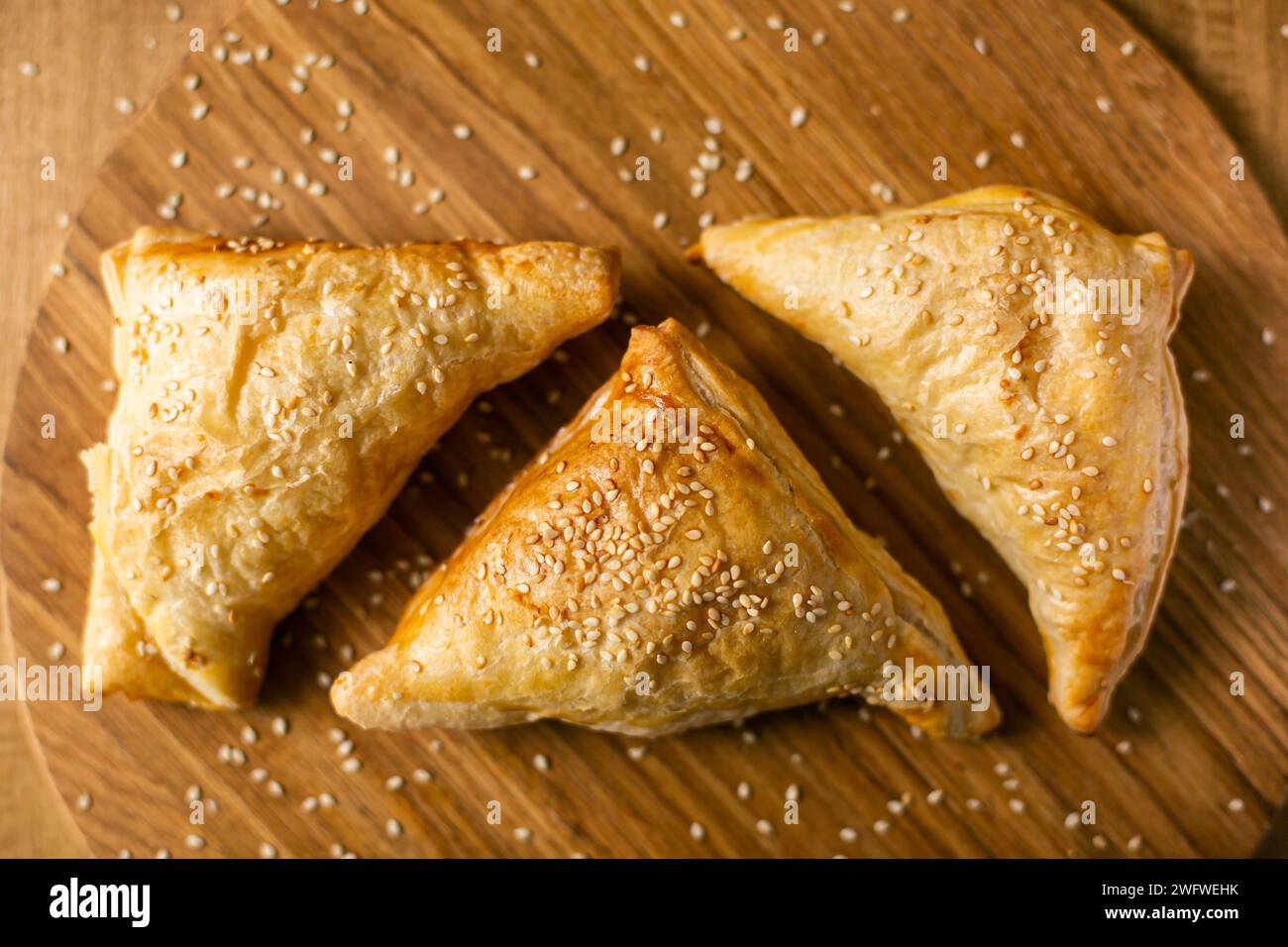 Triangoli di pasta sfoglia samosa di pasta asiatica fatta in casa su sfondo di legno. vista dall'alto Foto Stock