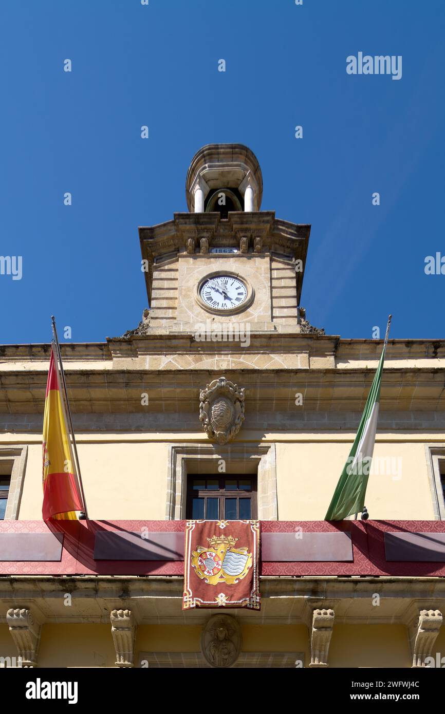 Vista del municipio di Jerez de la Frontera, con la sua torre dell'orologio e le sue bandiere, sotto un cielo azzurro Foto Stock
