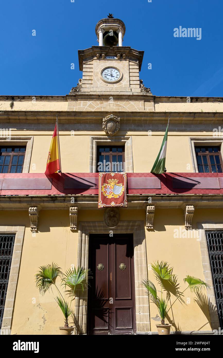 Vista del municipio di Jerez de la Frontera, con la sua torre dell'orologio e le sue bandiere, sotto un cielo azzurro Foto Stock