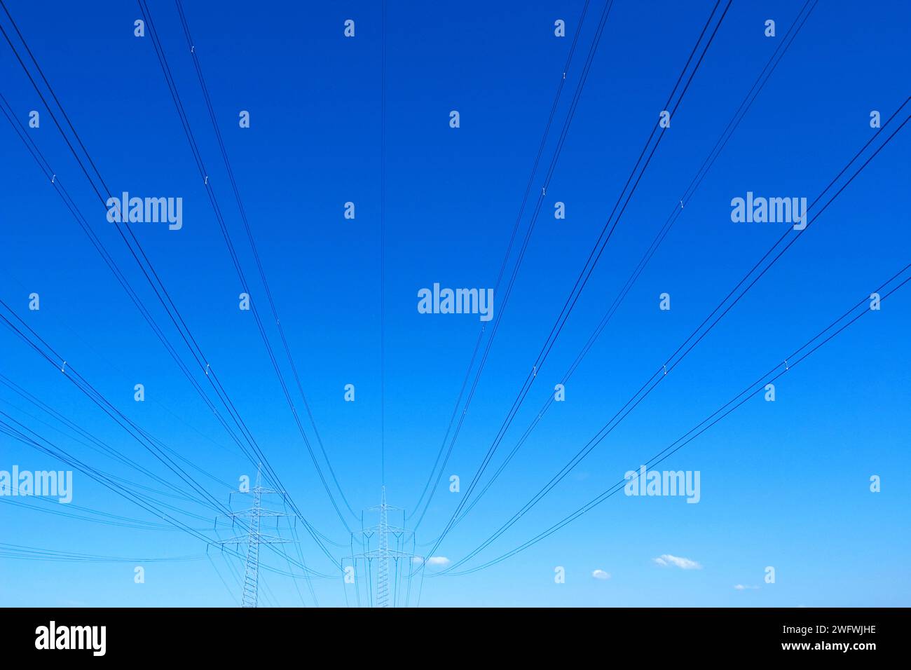 Linee ad alta tensione con piloni contro un cielo blu Foto Stock