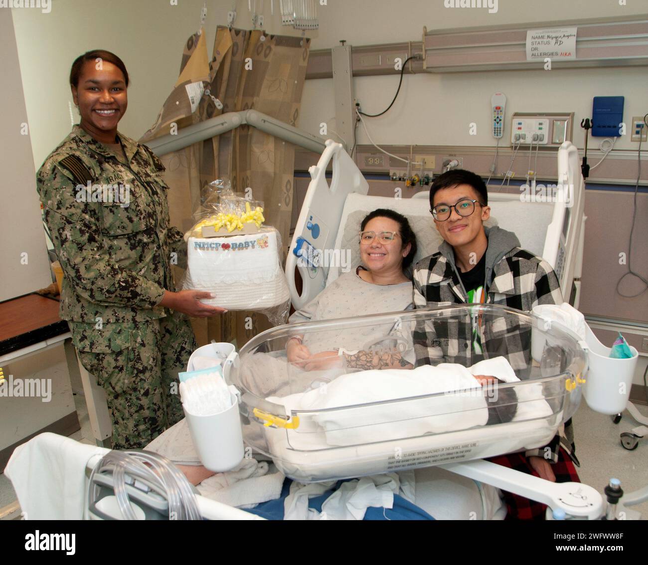 PORTSMOUTH, Va. (2 gennaio) è un ‘felice anno nuovo’ per due marinai che sono diventati genitori del primo bambino nato al Naval Medical Center di Portsmouth (NMCP), 1 gennaio. IT2 Angelina Nguyen, di stanza al Naval Special Warfare Group Four (NSWG4), diede alla luce Mahina alle 5:08 del mattino del primo giorno del nuovo anno. Suo marito, IT2 Kevin Nguyen, di stanza alla Beach Master Unit (BMU) 2, era al fianco di sua moglie quando ricevette il primo cestino Baby Born 2024 fornito ogni anno dall'Oakleaf Club of Tidewater. Il tenente j.g. Mikala Tracy, l'infermiera del paziente, ha presentato il cestino riempito con vari articoli per neonati a Th Foto Stock