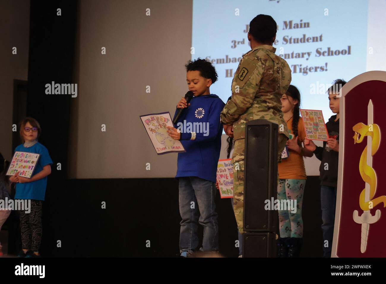 Jaxson Main, studente di terza elementare alla Sembach Elementary School, dà un'introduzione prima di una performance di otto studenti al Martin Luther King Jr. Osservazione del giorno al Tiger Theater, Sembach Kaserne, Germania, il 16 gennaio 2024. Gli studenti condussero per la prima volta una lettura di poesie in cui facevano riferimento al famoso discorso del Dr. King "i Have a Dream", seguito da due esibizioni di canzoni che evidenziavano l'importanza del movimento per i diritti civili e delle azioni di MLK durante quel periodo. La celebrazione di quest'anno segna il 37° anno in cui l'America ha messo da parte del tempo per riflettere sulla vita di MLK e della sua Foto Stock