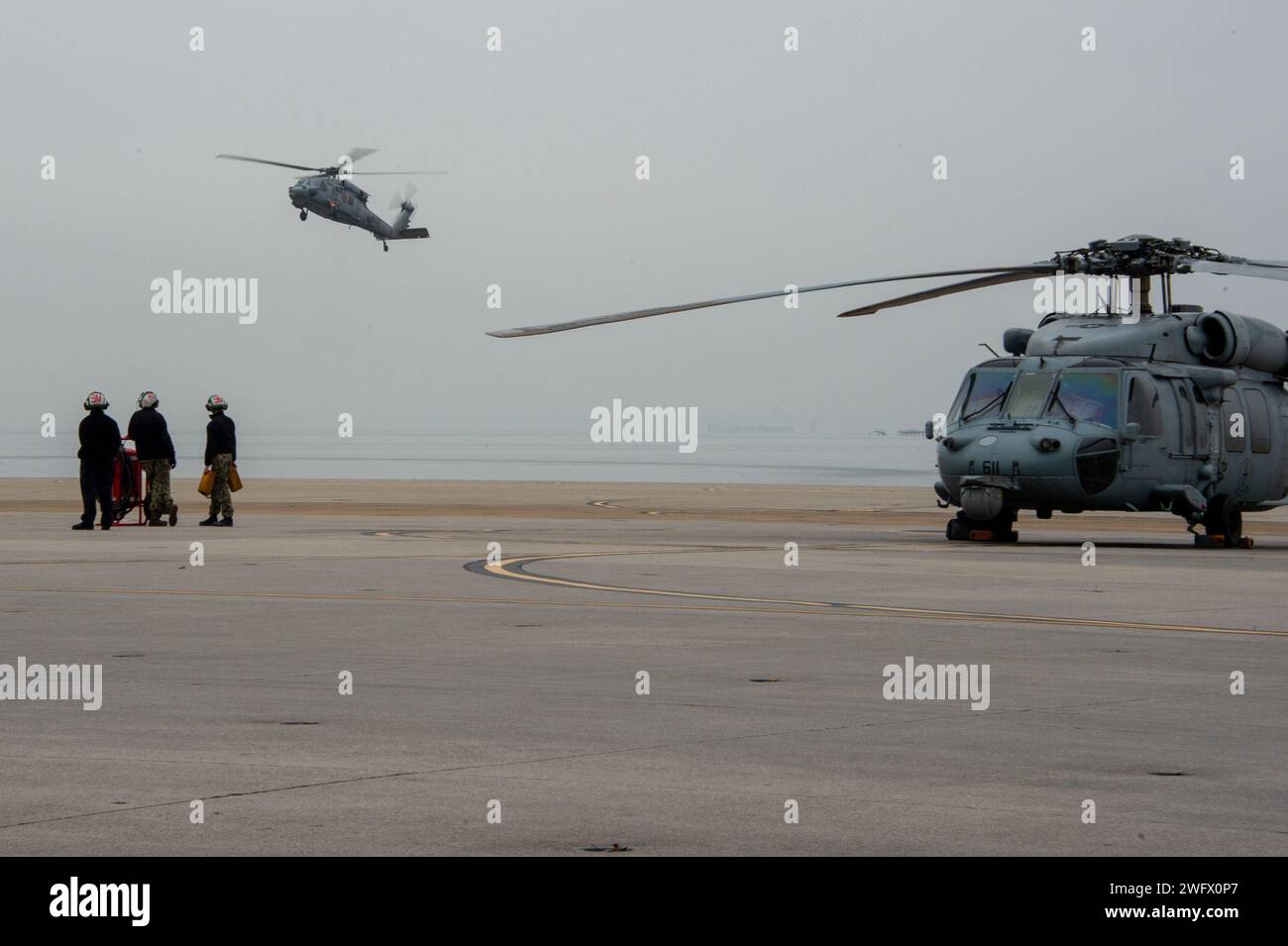 NORFOLK, Va. (16 gennaio 2024)- un MH-60S, assegnato ai "Tridents" dell'Helicopter Sea Combat Squadron (HSC) 9, si prepara ad atterrare al loro ritorno alla base navale di Norfolk in Virginia, 16 gennaio, dopo un dispiegamento di oltre otto mesi con il Gerald R. Ford Carrier Strike Group. Mentre era schierato, lo squadrone ha compiuto il volo per oltre 2.200 ore di volo, eseguendo 46 giorni di evoluzioni di rifornimento verticale, spostando oltre 500 persone ed eseguendo sei evacuazioni tattiche. Foto Stock