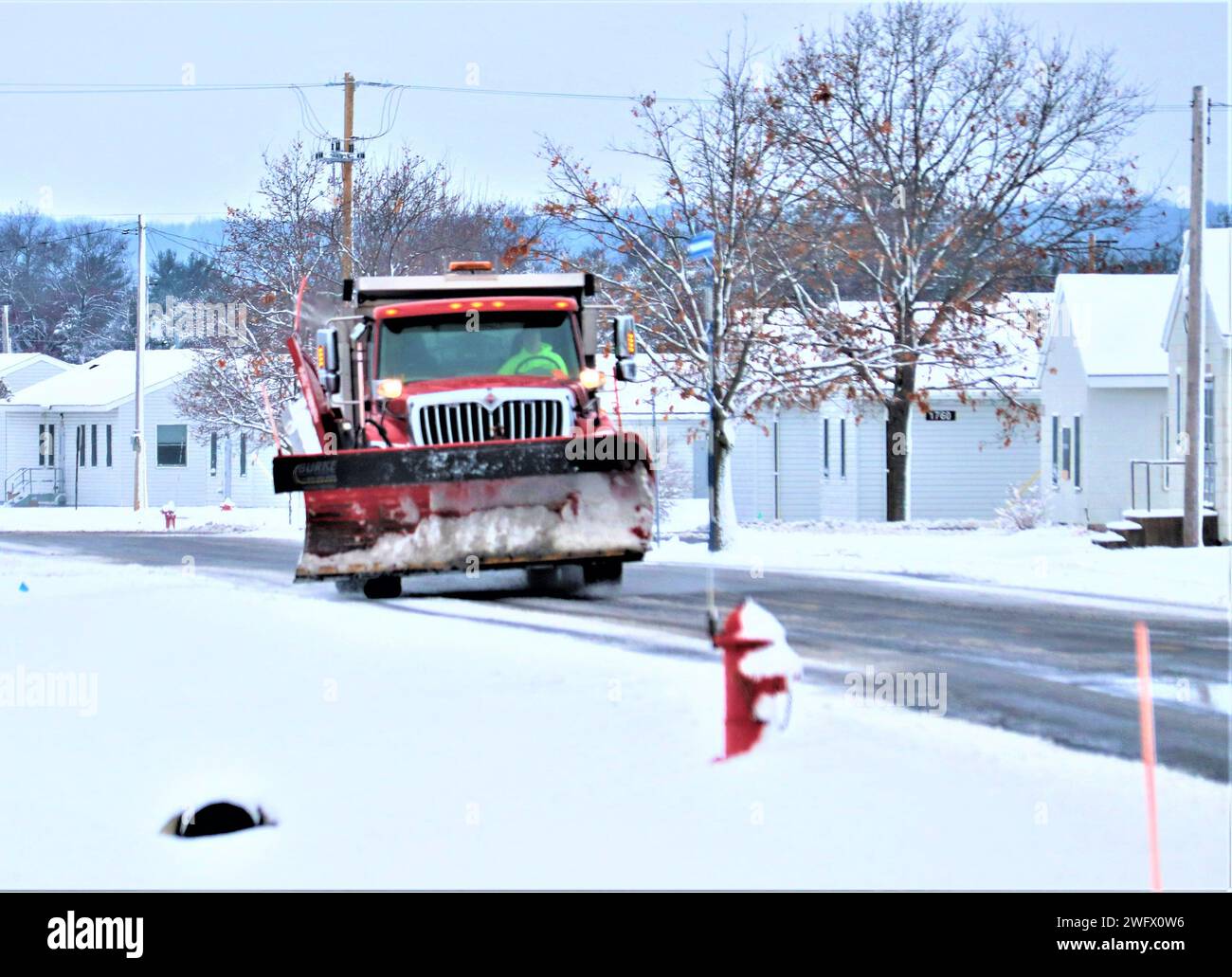 Un operatore di attrezzature con il team di rimozione della neve di Fort McCoy sgombererà la neve il 10 gennaio 2024 a Fort McCoy, Wisconsin. L'inverno e la primavera nel Wisconsin possono fornire tutti i tipi di maltempo, tra cui pioggia ghiacciata, neve o nevischio in qualsiasi momento o anche tutto in un solo giorno. Quando ciò accade, la squadra di rimozione della neve di Fort McCoy si arancia in qualsiasi cosa madre natura possa gustare. Il team comprende l'appaltatore Kaiyuh Services LLC, il personale della direzione dei lavori pubblici e molti altri. Il team aiuta a mantenere sgombri oltre 400 chilometri di strade, marciapiedi e aree di parcheggio, in modo che la forza lavoro di Fort McCoy possa operare in sicurezza. Foto Stock