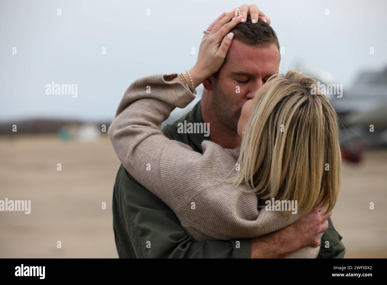 240115-N-YM590-1184 VIRGINIA BEACH, Va. (15 gennaio 2024)- Un pilota, assegnato al "Golden Warriors" dello Strike Fighter Squadron (VFA) 87, si riunisce con la sua famiglia dopo essere tornato alla Naval Air Station Oceana in Virginia, 15 gennaio, dopo più di otto mesi di schieramento con il Gerald R. Ford Carrier Strike Group. Mentre era schierato, lo squadrone realizzò 1.473 trappole per portaerei che coprono 2.418 ore di volo. Foto Stock