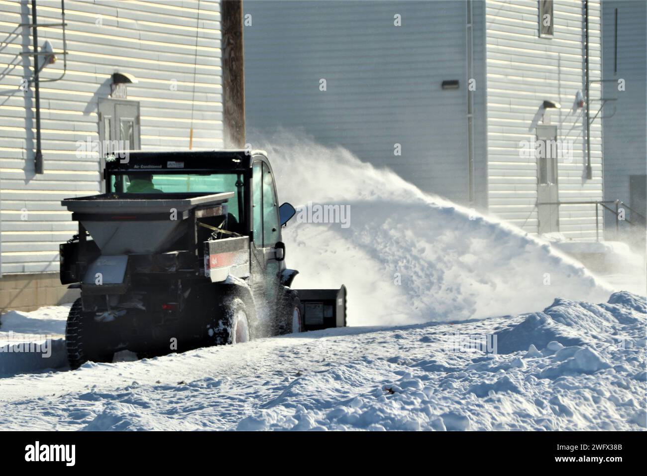 Un operatore di attrezzature con il team di rimozione della neve di Fort McCoy sgombererà la neve il 16 gennaio 2024 a Fort McCoy, Wisconsin. L'inverno e la primavera nel Wisconsin possono fornire tutti i tipi di maltempo, tra cui pioggia ghiacciata, neve o nevischio in qualsiasi momento o anche tutto in un solo giorno. Quando ciò accade, la squadra di rimozione della neve di Fort McCoy si arancia in qualsiasi cosa madre natura possa gustare. Il team comprende l'appaltatore Kaiyuh Services LLC, il personale della direzione dei lavori pubblici e molti altri. Il team aiuta a mantenere sgombri oltre 400 chilometri di strade, marciapiedi e aree di parcheggio, in modo che la forza lavoro di Fort McCoy possa operare in sicurezza. Foto Stock