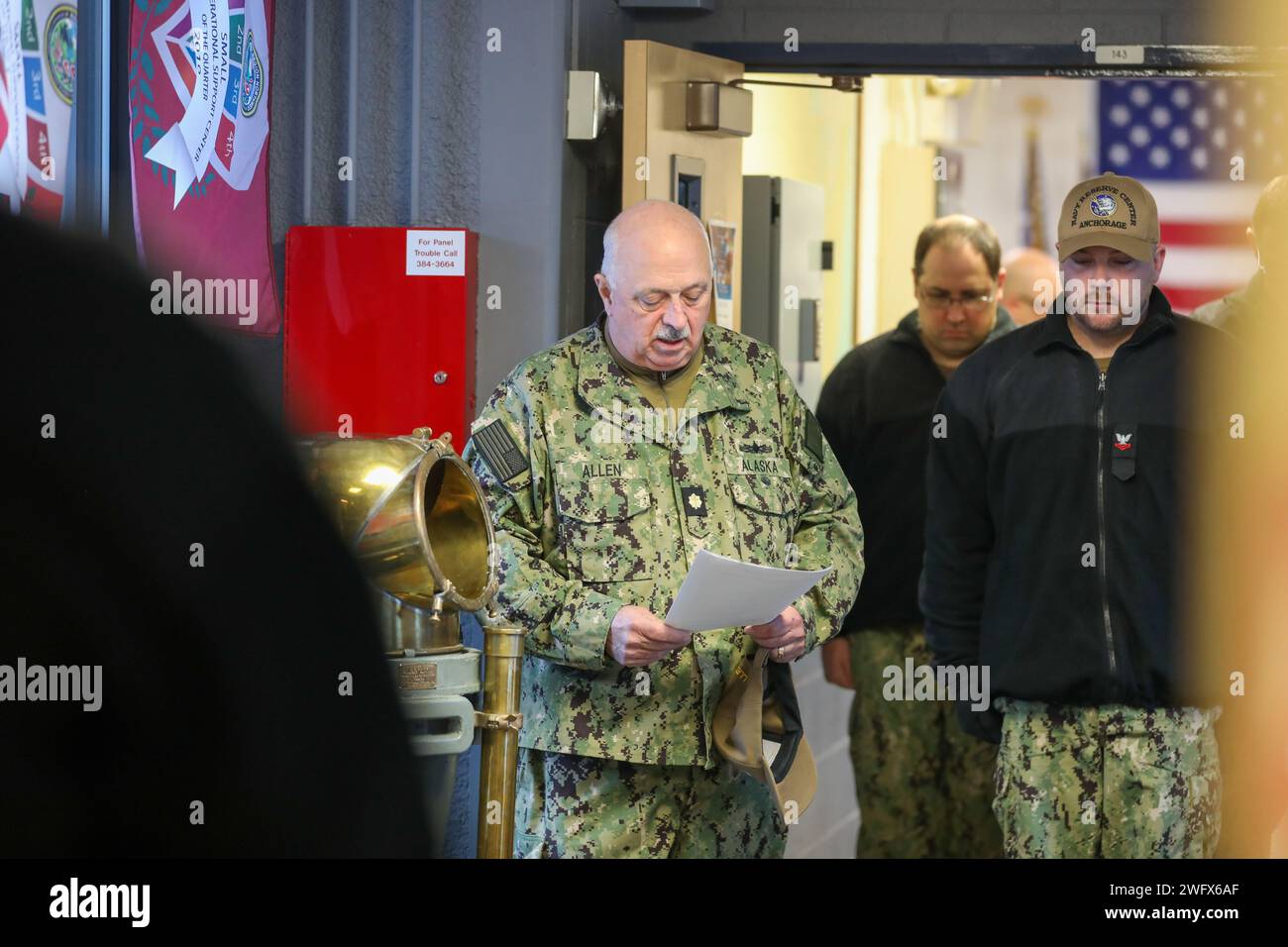 Tenente Cmdr. (AK) David Allen, capo di stato maggiore della milizia navale dell'Alaska, offre una preghiera silenziosa per i compagni di nave in partenza durante una cerimonia commemorativa di due Bell presso il U.S. Navy Reserve Center sulla base congiunta Elmendorf Richardson, Alaska, 24 gennaio 2024. Dopo la cerimonia di commemorazione, fu innalzata una bandiera in onore del sottomarino S-26 e dell'equipaggio che furono persi il 24 gennaio 1942. L'evento commemorativo ha sottolineato l'unità e l'impegno condiviso tra le componenti navali per onorare i sacrifici fatti dai sottomarini nel corso della storia. (Alaska National Guard Foto Stock
