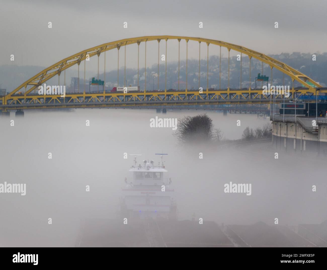 Una towboat organizza chiatte in condizioni di nebbia sul fiume Ohio a Pittsburgh, 25 gennaio 2024. Il U.S. Army Corps of Engineers Pittsburgh District gestisce 23 chiuse navigabili e dighe sui fiumi Allegheny, Monongahela e Ohio tutto l'anno, indipendentemente dalle condizioni meteorologiche, anche in condizioni di nebbia che limitano la visibilità. Molti equipaggi di barche a rimorchio continuano a lavorare sui fiumi anche nella nebbia, talvolta mettendo in scena le loro chiatte lungo varie parti lungo i corsi d'acqua di Pittsburgh mentre aspettano che la nebbia si sollevi. Indipendentemente dal tempo, le chiuse e le dighe del distretto di Pittsburgh rimangono aperte al traffico, leggi Foto Stock