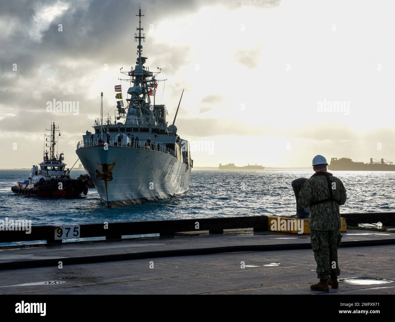 230901-N-EJ241-1024 DIEGO GARCIA, territorio britannico dell'Oceano Indiano – Mate del Chief Machinist Luke K. Adams, assegnato alla U.S. Navy Support Facility Diego Garcia, guarda come la fregata canadese Halifax HMCS Montreal (FFH 336) arriva a Diego Garcia per una visita programmata al porto 1 settembre 2023. La visita ha sottolineato l'importanza strategica di Diego Garcia per un indo-Pacifico libero e aperto duraturo, consentendo la presenza, garantendo l'accesso e fornendo difesa ai comuni globali. Foto Stock