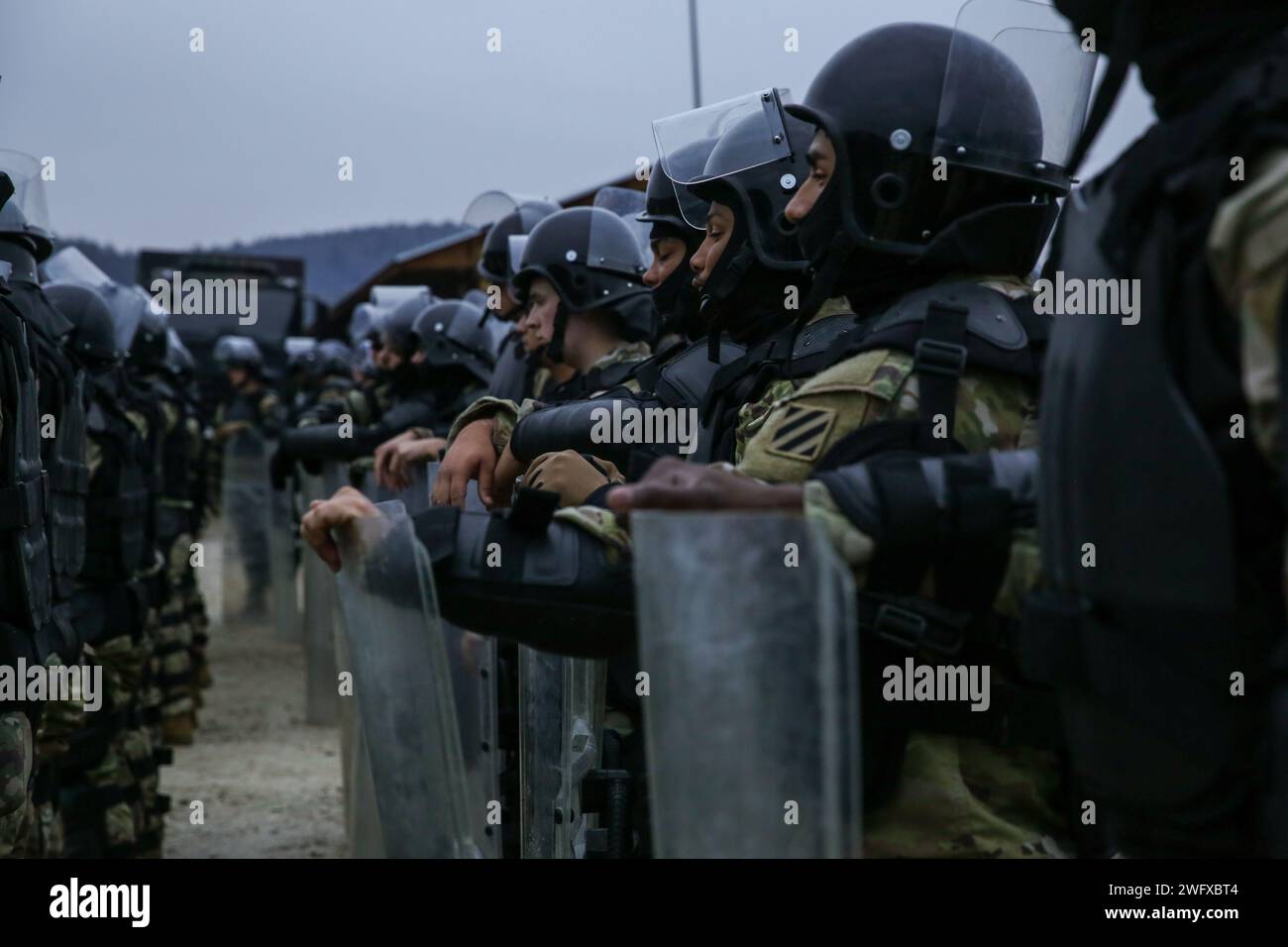 I soldati statunitensi assegnati alla 48th Infantry Brigade Combat Team (IBCT), Georgia Army National Guard (GA ARNG), si preparano per l'addestramento al controllo della folla durante il Kosovo Forces 33 nella Hohenfels Training area, Germania, 31 gennaio 2024. KFOR 33 è un evento di formazione multinazionale condotto per preparare il 48° IBCT (GA ARNG) per il loro dispiegamento al comando regionale del Kosovo Est. Foto Stock