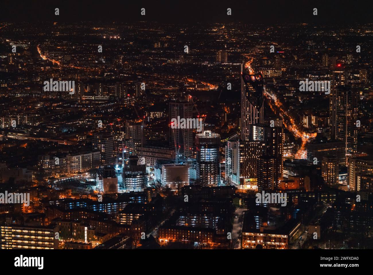 Vista aerea del sud-ovest di Londra, subito dopo il tramonto, le luci di strada arancioni gialle iniziano a brillare Foto Stock