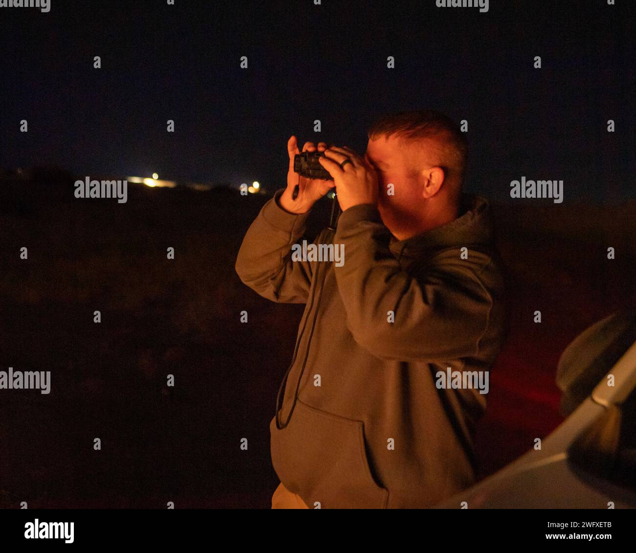 Lee Taylor, biologo della fauna selvatica del Dipartimento dell'Agricoltura degli Stati Uniti assegnato all'ufficio di sicurezza del 406th Air Expeditionary Wing, monitora lo spazio intorno all'aeroporto di Air base 201, Niger, durante un sondaggio notturno sulla fauna selvatica il 17 gennaio 2024. L'indagine sulla fauna selvatica fa parte del programma Bird/Wildlife Aircraft Strike Hazard per monitorare e scoraggiare gli animali che potrebbero rappresentare una minaccia per gli aerei e l'ambiente dell'aeroporto. Foto Stock