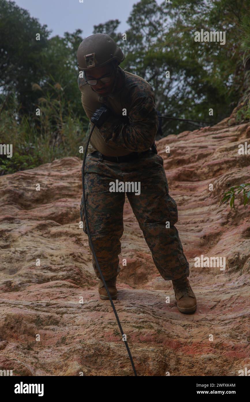 U.S. Marine Corps Sgt. Kanye Cheffin, un operatore di trasporto a motore con 3d Battalion, 12th Marine Littoral Regiment, 3d Marine Division, Rappels during a Basic Jungle Skills Course at the Jungle Warfare Training Center on Camp Gonsalves, Okinawa, Giappone, 9 gennaio 2024. BJSC insegna ai Marines abilità di sopravvivenza nella giungla di base, tecniche tattiche di sospensione della corda e tattiche di guerra nella giungla per migliorare la letalità negli ambienti difficili della giungla. Cheffin è nativo dell'Illinois. Foto Stock