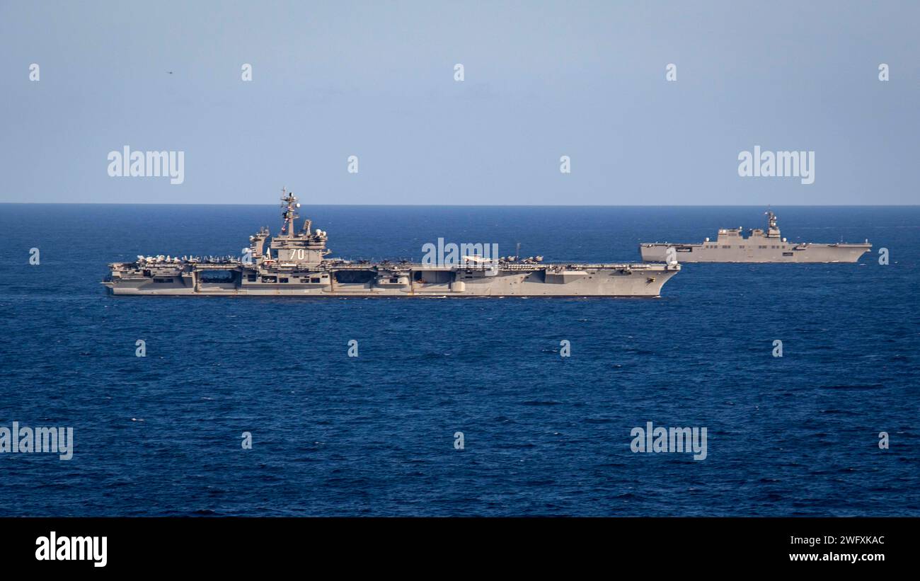 240117-N-TD381-1547 IN MARE (17 gennaio 2024) la portaerei classe Nimitz USS Carl Vinson (CVN 70), a sinistra, e il cacciatorpediniere elicottero classe Hyuga JS Hyuga (DDH-181) della Japan Maritime Self-Defense Force, salpano insieme durante un esercizio trilaterale, 17 gennaio. L'esercitazione permise alle forze marittime del Giappone, della Repubblica di Corea e degli Stati Uniti di addestrarsi insieme per migliorare il coordinamento sulla consapevolezza del dominio marittimo e su altri interessi di sicurezza condivisi. La Vinson, ammiraglia del Carrier Strike Group ONE, è dispiegata nell'area operativa della settima flotta degli Stati Uniti a sostegno di una Indo-Pacifico libera e aperta. Foto Stock