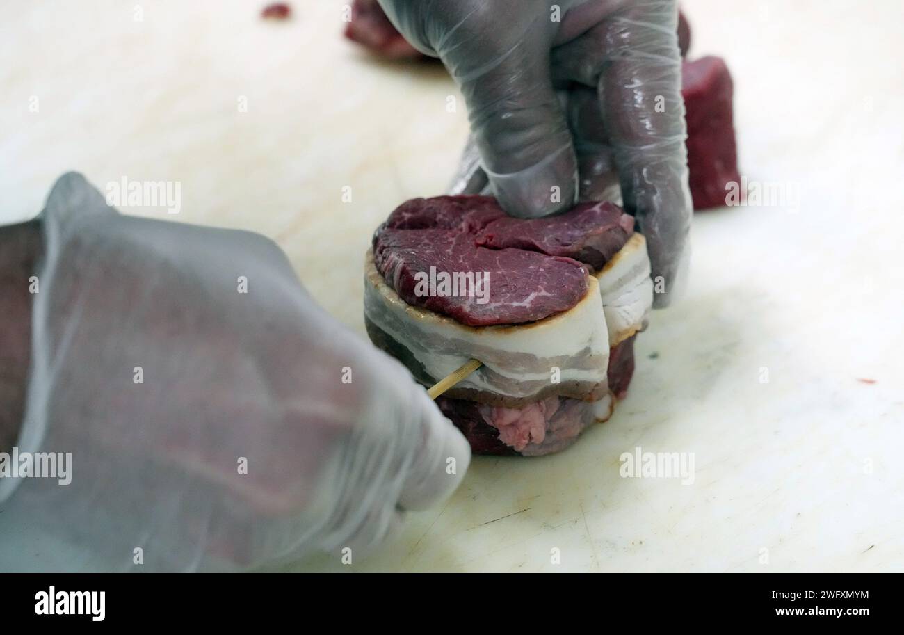 St Louis, Stati Uniti. 5 febbraio 2024. Il macellaio Jim Legrand attacca una striscia di pancetta a una bistecca mignon di filetto a forma di cuore da 250 ml che sta preparando per lo speciale del negozio, cena per due, per San Valentino al Legrand's Market di St. Louis giovedì 1 febbraio 2024. Per $60 Legrand's preparerà un pasto completamente cotto che include due bistecche a forma di cuore, broccoli, carbonara di pasta, insalata e mini torte al formaggio, perfetto per due. Foto di Bill Greenblatt/UPI credito: UPI/Alamy Live News Foto Stock