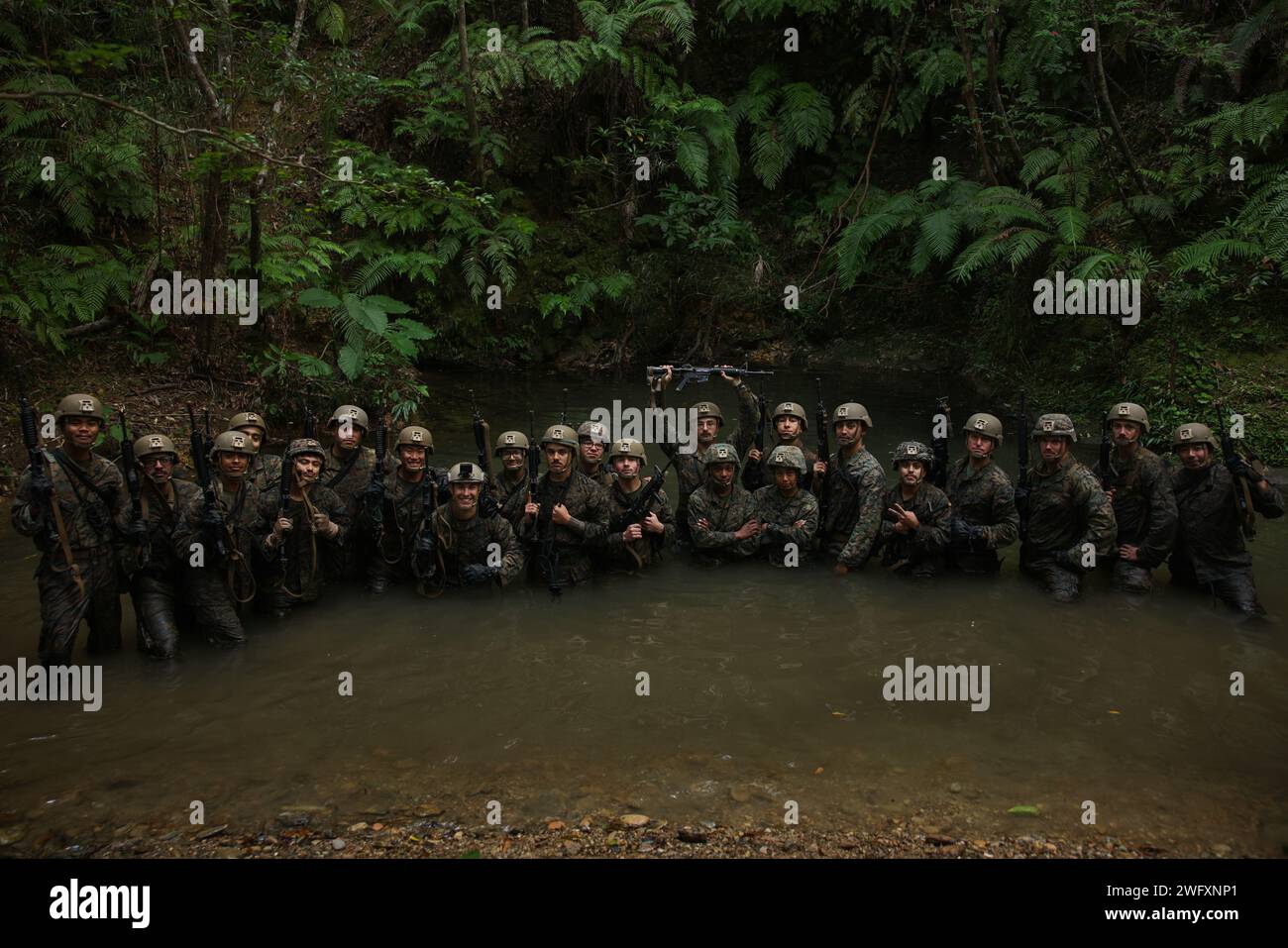 U.S. Marines with III Marine Expeditionary Force posa per una foto durante un corso Basic Jungle Skills presso il Jungle Warfare Training Center a Camp Gonsalves, Okinawa, Giappone, 12 gennaio 2024. BJSC insegna ai Marines abilità di sopravvivenza nella giungla di base, tecniche tattiche di sospensione della corda e tattiche di guerra nella giungla per migliorare la letalità negli ambienti difficili della giungla. Il 4th LAR Battalion è schierato in avanti nell'Indo-Pacifico come parte del 3d Marine Division Unit Deployment Program. Foto Stock