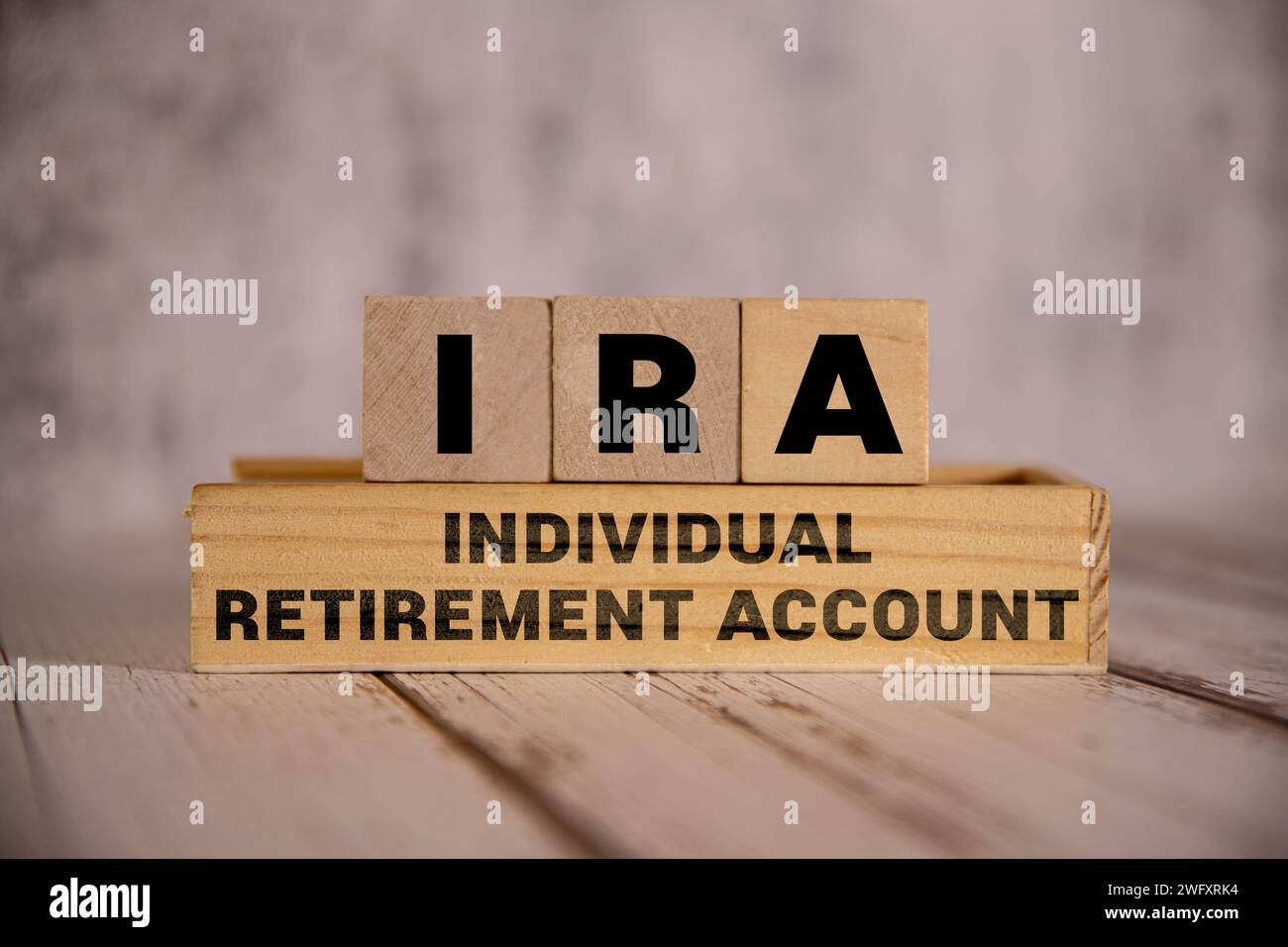 Su uno sfondo blu brillante, blocchi e cubi di legno chiaro con il testo IRA Individual Retirement account. Foto Stock