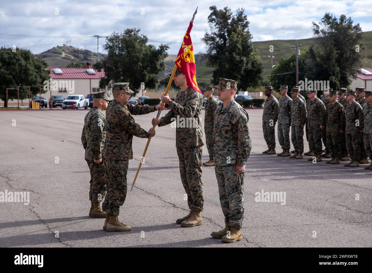 Il tenente del corpo dei Marines Jeremy Colwell, secondo da sinistra, comandante del 2nd Battalion, 11th Marine Regiment, 1st Marine Division, passa una nuova batteria guidon ai Marines durante una cerimonia di ridesignazione alla base dei Marines Camp Pendleton, California, 10 gennaio 2024. La cerimonia è stata ufficialmente ribattezzata Bravo Battery, 1st BN., 11th Marines, come Hotel Battery, 2nd Bn., 11th Marines. La ridesignazione faceva parte di una più ampia riorganizzazione dell'11th Marines sotto Force Design. Foto Stock