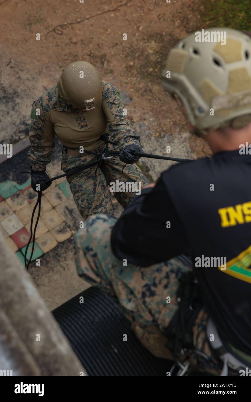 Il caporale del corpo dei Marines degli Stati Uniti Kiara Salas, un tecnico di munizioni con 3d Battalion, 12th Marine Littoral Regiment, 3d Marine Division, rappels durante un corso di abilità nella giungla di base presso il Jungle Warfare Training Center a Camp Gonsalves, Okinawa, Giappone, 9 gennaio 2024. BJSC insegna ai Marines abilità di sopravvivenza nella giungla di base, tecniche tattiche di sospensione della corda e tattiche di guerra nella giungla per migliorare la letalità negli ambienti difficili della giungla. Salas è nativo della Carolina del Nord. Foto Stock