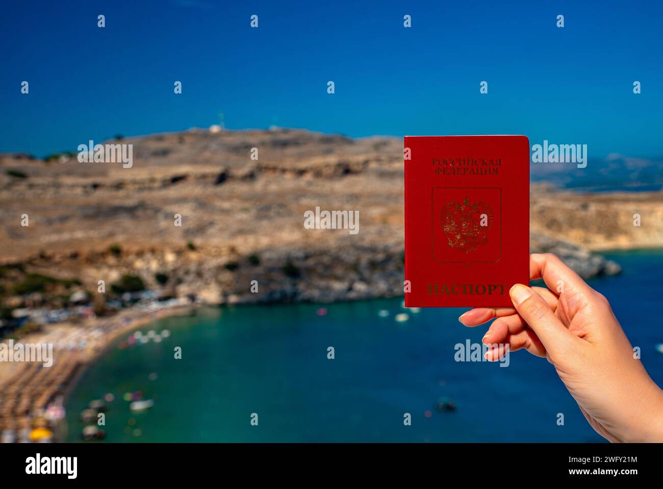 Donna in possesso di passaporto russo sullo sfondo di un paese tropicale. Foto Stock